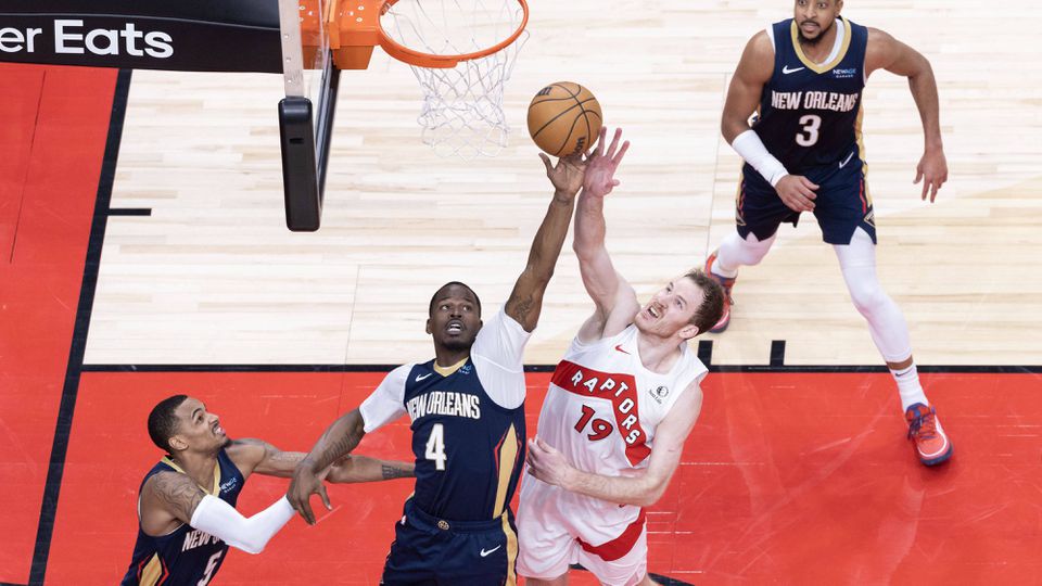 Javonte Green, dos New Orleans Pelicans, luta pelo ressalto com Jakob Poeltl, dos Toronto Raptors, durante o jogo entre as duas equipas