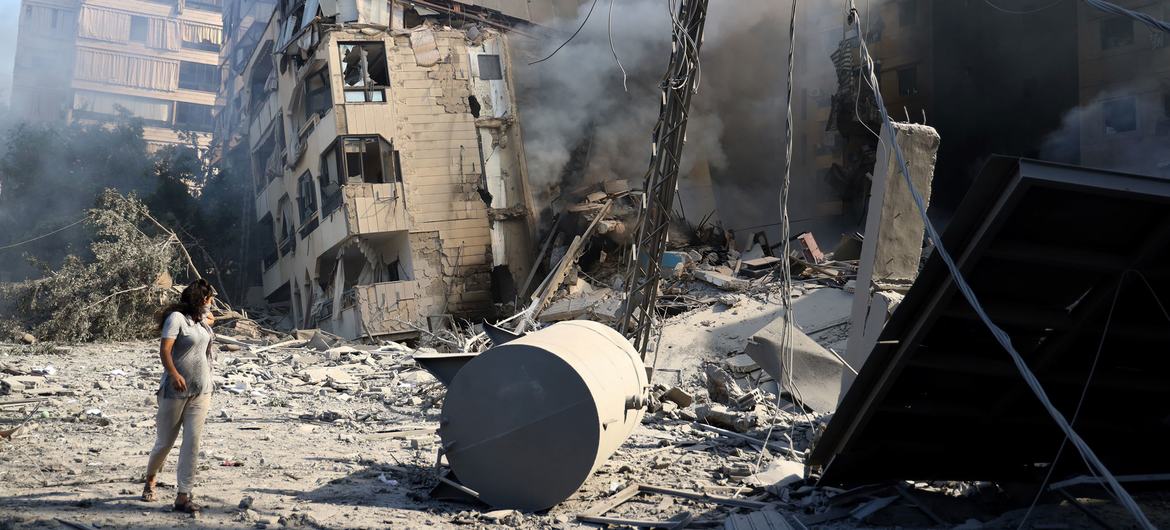 Uma mulher passa por um prédio destruído nos subúrbios ao sul de Beirute, capital libanesa