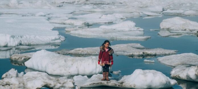 Uma menina da comunidade Iñupiat está em um bloco de gelo na costa do Oceano Ártico em Barrow, Alasca, nos Estados Unidos