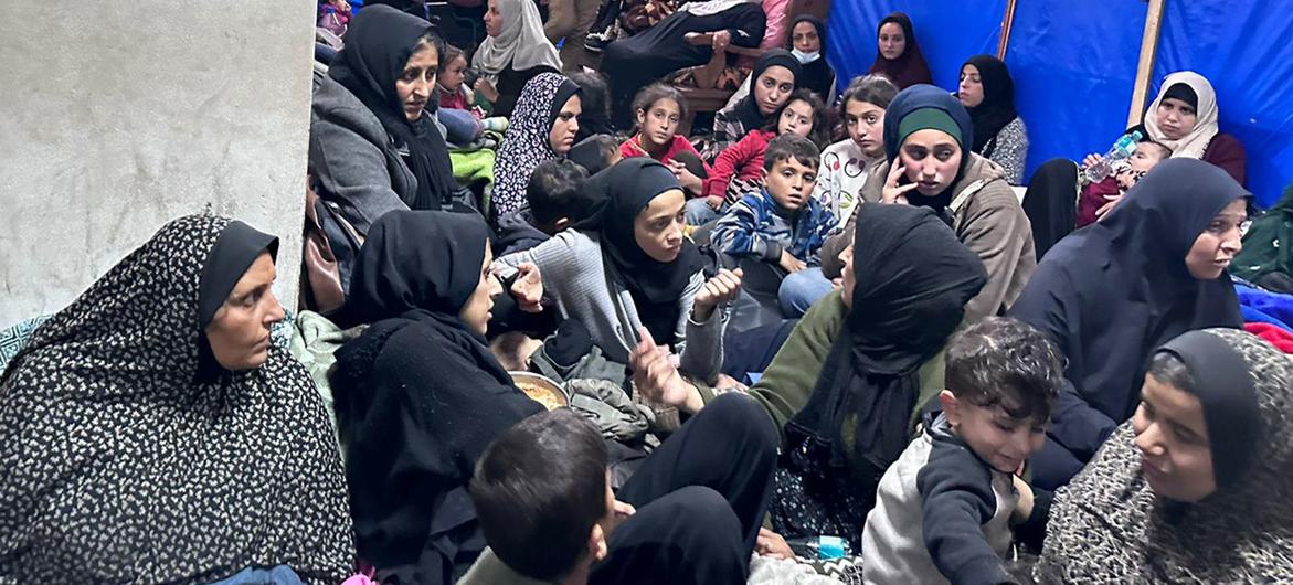 Mulheres e crianças se abrigam em uma instalação superlotada da UNRWA em Khan Younis, Gaza, em meio a tiros e bombardeios próximos