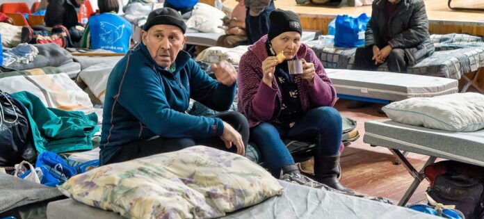 Pessoas deslocadas pela guerra na Ucrânia permanecem num centro de trânsito no Dnipro