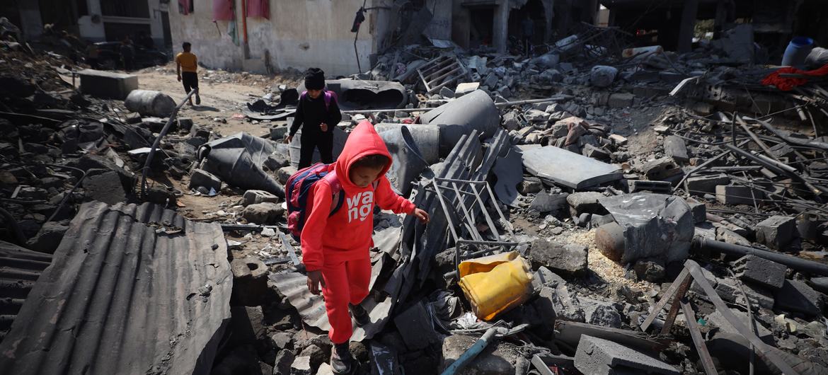 Crianças palestinas escalam escombros após ataques aéreos em 18 de março