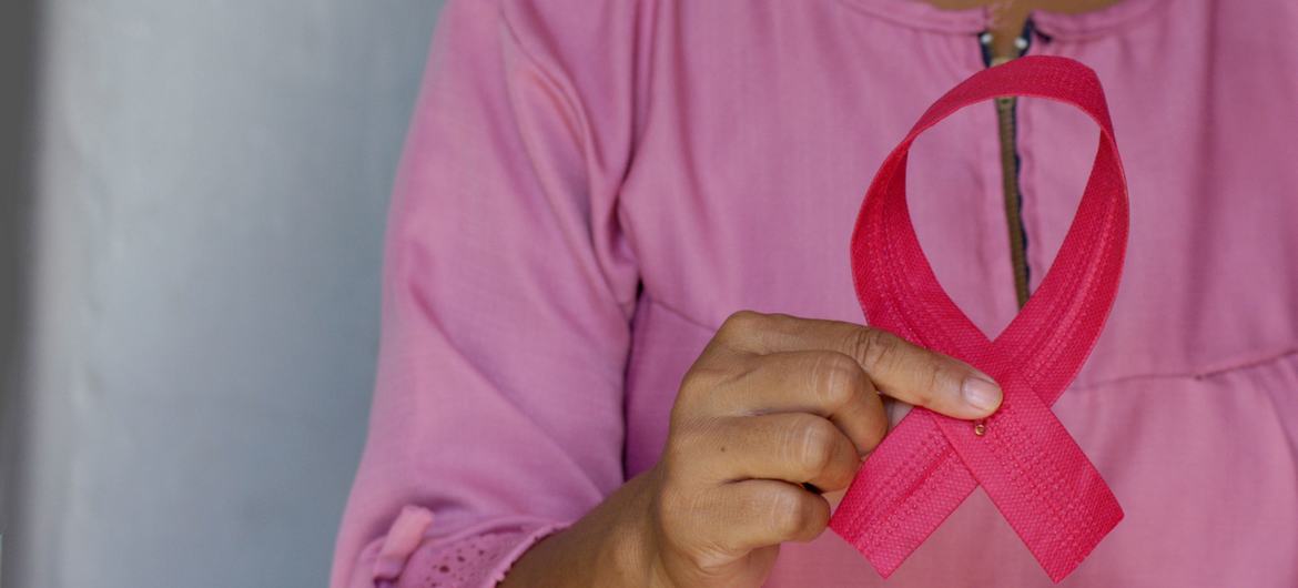 Uma mulher segura uma fita rosa em comemoração ao Dia Mundial de Combate ao Câncer de Mama
