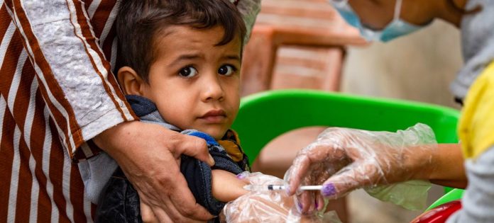 Uma criança recebeu uma vacina de um funcionário do Departamento de Saúde no bairro de Ghwairan, cidade de Hasakeh, nordeste da Síria