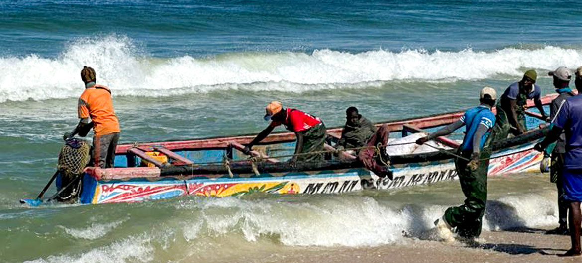Homens atracam em um barco de pesca mauritano, conhecido como piroga Homens atracam em um barco de pesca mauritano, conhecido como piroga