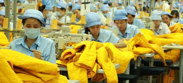 Trabalhadoras de uma fábrica têxtil no Vietnã costuram jaquetas, destinadas principalmente aos mercados ocidentais