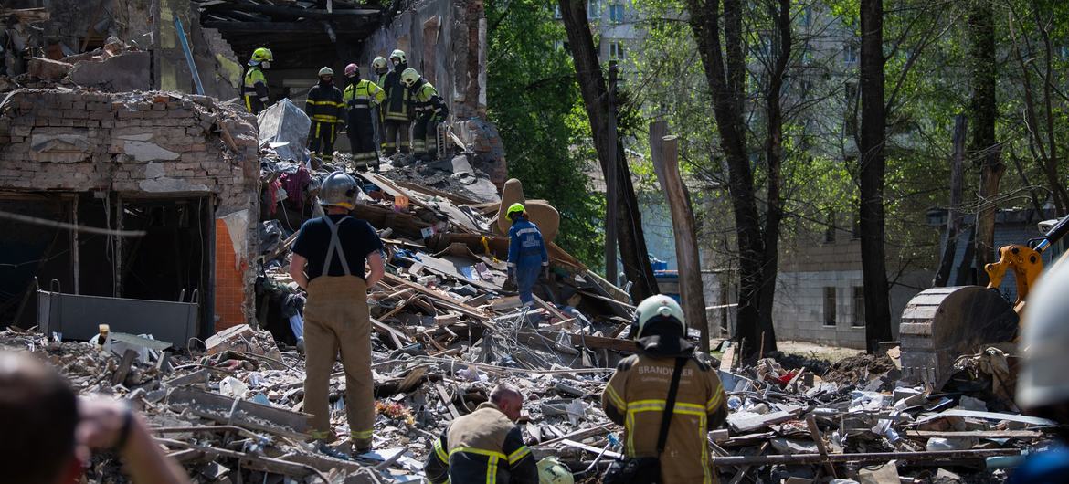 Equipes de resgate escavam os escombros de um prédio bombardeado em Kyiv, Ucrânia