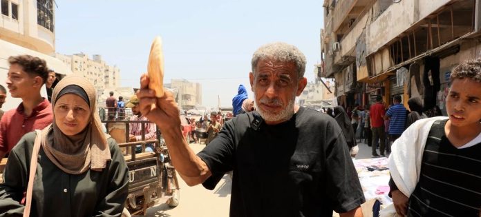 Zuhair Obaid carrega um pedaço de pão