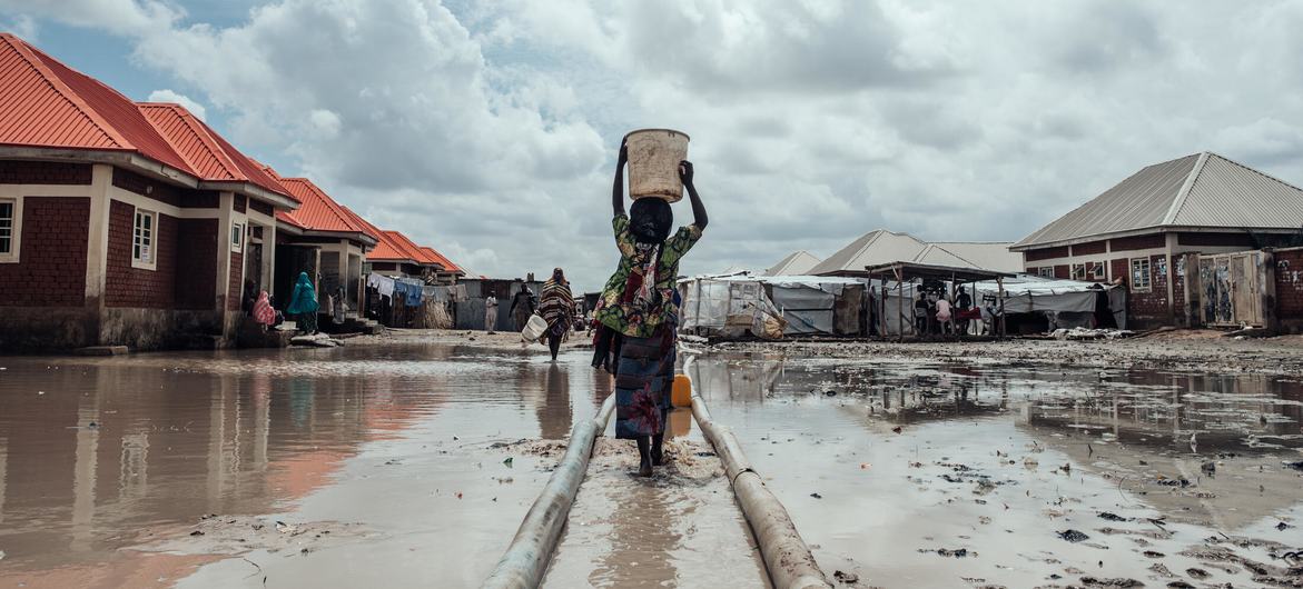 Milhões continuam deslocados em toda a Nigéria devido a conflitos, impactos das alterações climáticas e catástrofes naturais. Nesta foto de arquivo, uma menina leva água para seu abrigo em um campo de deslocados internos no nordeste do país Milhões continuam deslocados em toda a Nigéria devido a conflitos, impactos das alterações climáticas e catástrofes naturais. Nesta foto de arquivo, uma menina leva água para seu abrigo em um campo de deslocados internos no nordeste do país