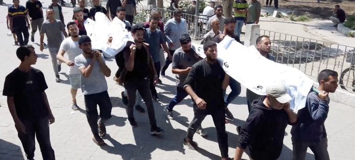 Palestinos dentro do Hospital Ahli carregando os corpos de seus parentes mortos em ataques aéreos israelenses em Gaza