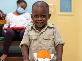 Um menino de dois anos diagnosticado com leucemia e tratado com quimioterapia brinca enquanto espera para ver um médico em um hospital em Gana