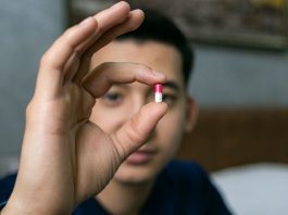 Um homem no Uzbequistão mostra o medicamento que toma para combater o HIV