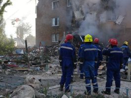 Bombeiros trabalham entre os escombros de um prédio residencial em Kyiv destruído por um ataque de míssil em 28 de agosto