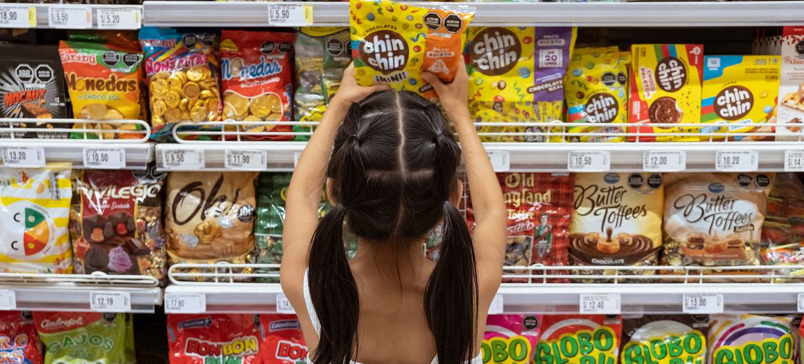 Uma jovem escolhe doces em um supermercado em Lima, Peru
