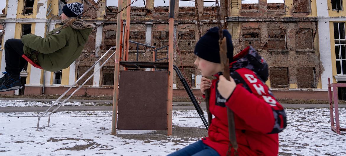 Meninos brincam em meio às ruínas de uma escola em Kharkiv, Ucrânia
