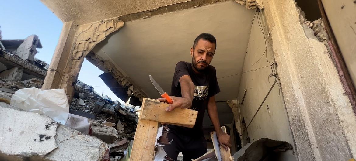 Hossam Madi, morador de Sheikh Radwan, no norte da Cidade de Gaza, retira alguns de seus pertences de sua casa destruída