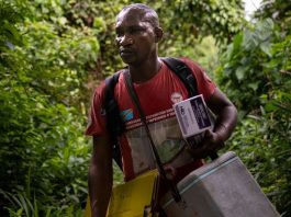 Uma enfermeira transporta vacinas para aldeias remotas às margens do Rio Congo, na República Democrática do Congo