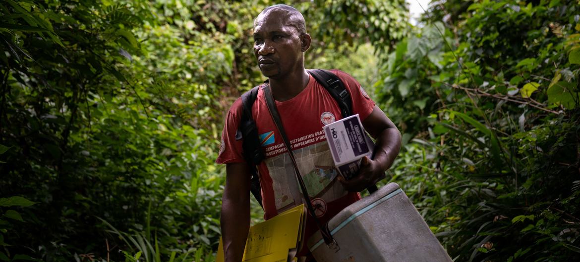 Uma enfermeira transporta vacinas para aldeias remotas às margens do Rio Congo, na República Democrática do Congo