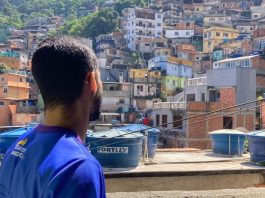 Funcionário do Carteiro Amigo observa a vista de uma favela no Rio de Janeiro