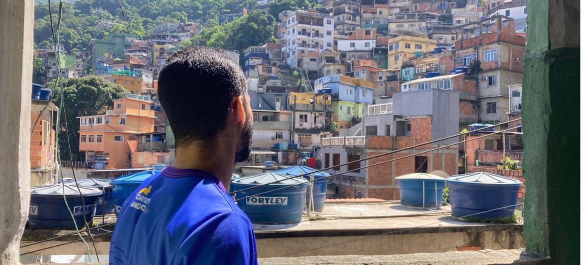 Funcionário do Carteiro Amigo observa a vista de uma favela no Rio de Janeiro