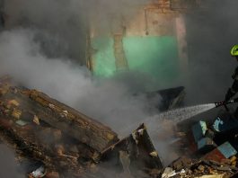 Um bombeiro trabalha em meio à fumaça espessa nas ruínas de um prédio residencial em Kiev, destruído por um ataque de míssil em 28 de agosto