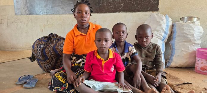 Uma mãe e três meninos se abrigam em uma sala de aula após fugirem da violência no norte de Moçambique