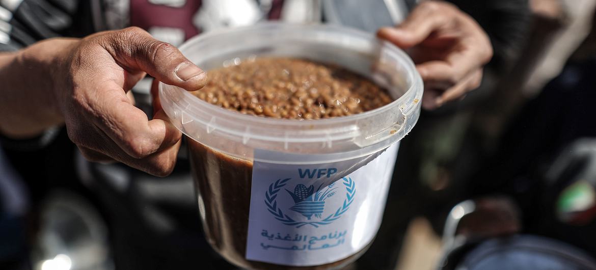 Morador de Gaza segura uma refeição quente distribuída pelo Programa Mundial de Alimentos da ONU. Morador de Gaza segura uma refeição quente distribuída pelo Programa Mundial de Alimentos da ONU.