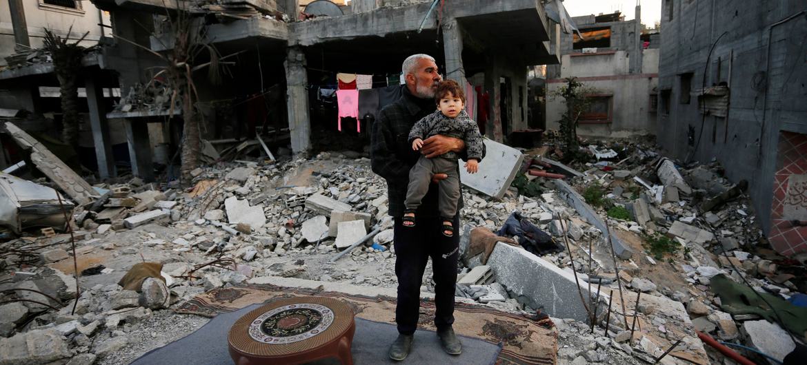 Um homem olha para os restos de casas destruídas na Faixa de Gaza Um homem olha para os restos de casas destruídas na Faixa de Gaza
