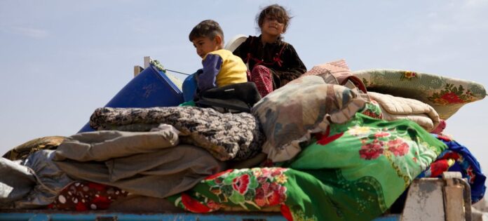 Uma família deslocada na Síria escapando dos combates perto de Idlib (agosto de 2023)