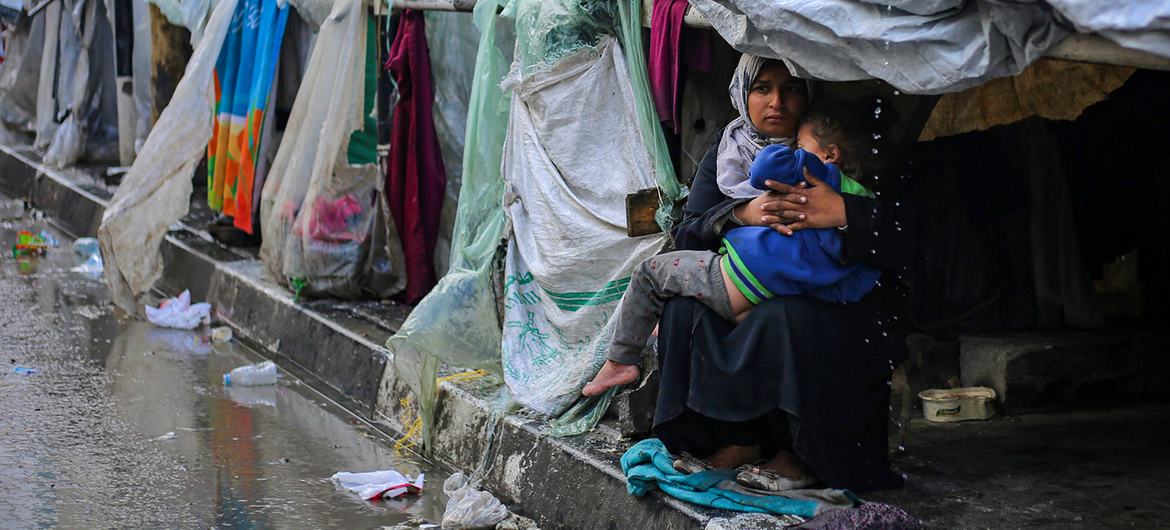 Uma mulher e seu filho se protegem da chuva na cidade de Rafah, no sul da Faixa de Gaza Uma mulher e seu filho se protegem da chuva na cidade de Rafah, no sul da Faixa de Gaza