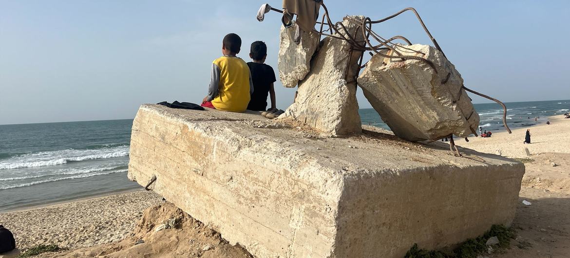Dois meninos contemplam o oceano em uma praia, em Rafah, Gaza, abril de 2024 Dois meninos contemplam o oceano em uma praia, em Rafah, Gaza, abril de 2024