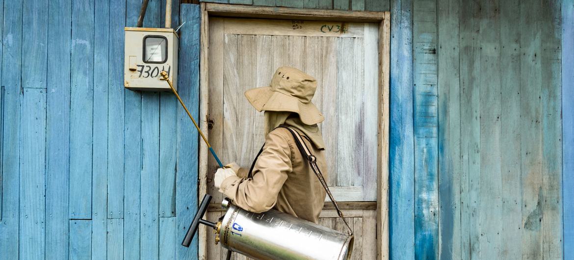 Um profissional de saúde fumiga uma casa em Guayaramerín, Bolívia, para protegê-la contra doenças transmitidas por mosquitos