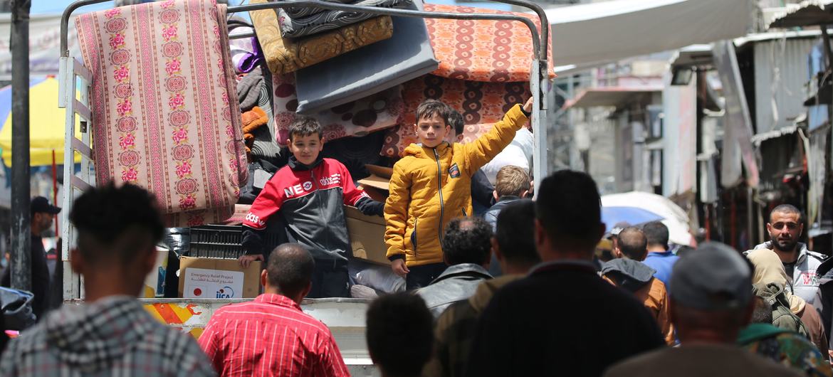 Duas crianças na traseira de um caminhão fugindo com a família de Rafah, no sul da Faixa de Gaza Duas crianças na traseira de um caminhão fugindo com a família de Rafah, no sul da Faixa de Gaza