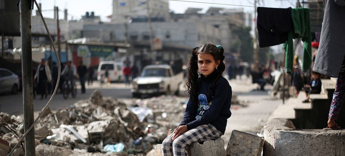 Uma menina de 11 anos está sentada nos escombros de uma casa em Rafah, no sul da Faixa de Gaza